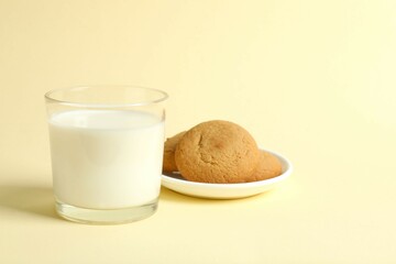 Glass of milk with cookies on color background 