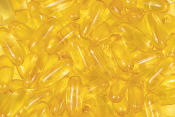 Omega 3 tablets background texture. yellow pills close up. Fish oil capsules. Golden vitamin D3