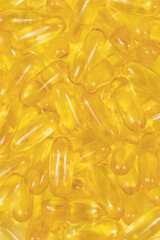 Omega 3 tablets background texture. yellow pills close up. Fish oil capsules. Golden vitamin D3