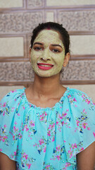 Beautiful young woman using homemade facial mask on face and relaxing at Home. Asian women with Multani Mitti and Rose Water face pack. Portrait of spa girl. Beauty, healthcare.