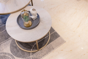 The marble coffee table rests on carpet and cream marble