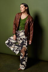 Brunette woman showcases her fashion sense with confidence in a trendy outfit and striking pose.