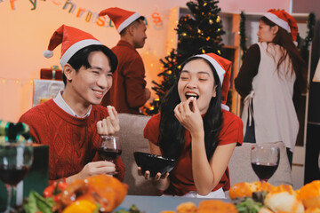 Group of young Asian man and women as friends having fun at a New Year's celebration, holding gift...
