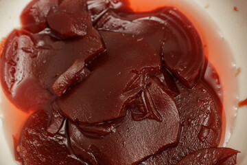 Close-up of glistening cranberry sauce, rich red color, textured surface, homemade or store-bought.