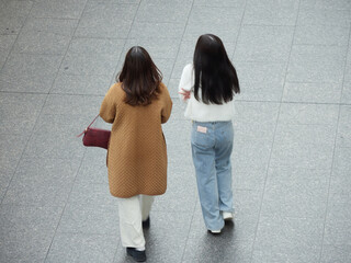 冬の朝の街の繁華街で歩く二人の女性観光客の姿