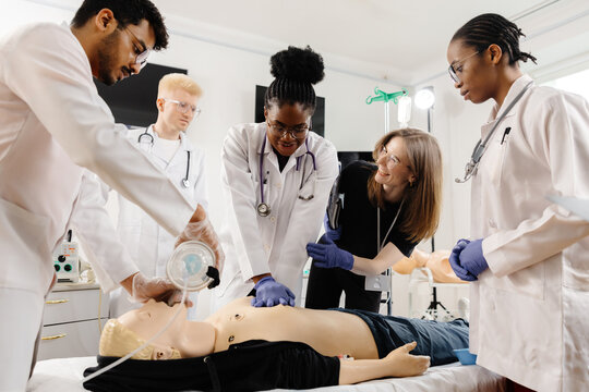 Medical personnel demonstrating cpr on dummy
