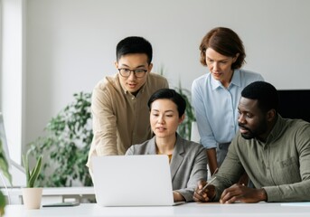 Diverse colleagues collaborating on a project, using a laptop and sharing ideas in a modern office environment