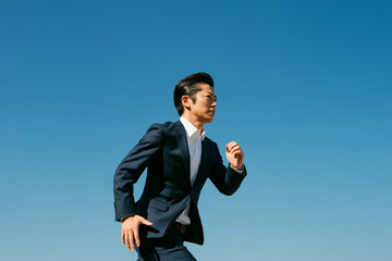 走る男性 スーツ ビジネスマン 空