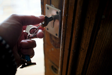 Hand unlocking a door with a key