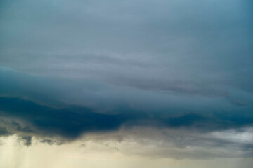 Dark storm clouds gather, indicating an approaching storm, with lighter clouds and a hint of sunset below, Norway