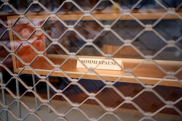 A sign reading SOMMERPAUSE summer break is visible behind a metal grid, indicating a seasonal closure, near Moselle River, Germany