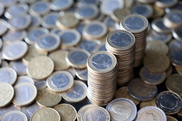 A close-up view of shiny euro coins stacked and scattered