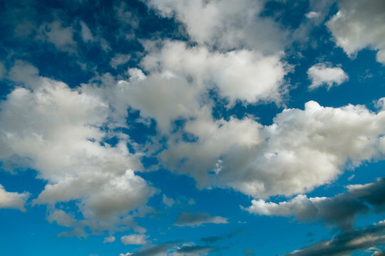 Fluffy white clouds against a vibrant blue sky.