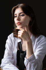 A young girl in a white shirt and black tie in the studio.