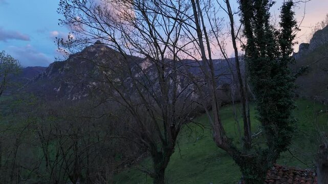 Drone flight over a spectacular landscape in the mountains of Quiros in Asturias, Spain with a sky of intense colors at sunset