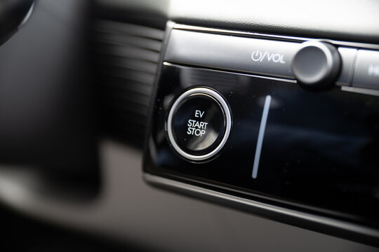 Closeup view of finger pressing the start stop button of an electric car