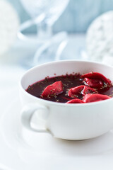 Traditional Christmas Borscht (Barszcz) with mushroom dumplings on bright background.
