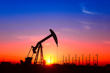 The pumping unit is working, in the silhouette of sunset