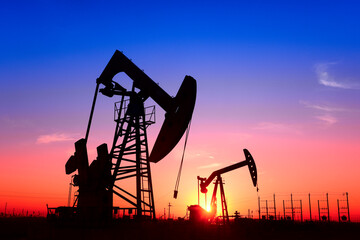 The pumping unit is working, in the silhouette of sunset