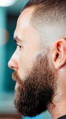 Fototapeta premium Close-up profile of a man with a stylish haircut and well-groomed beard, showcasing modern grooming trends, Suitable for articles, blogs, or advertising related to men's grooming or hairstyling,