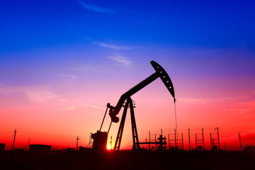 The pumping unit is working, in the silhouette of sunset
