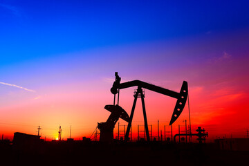 The pumping unit is working, in the silhouette of sunset