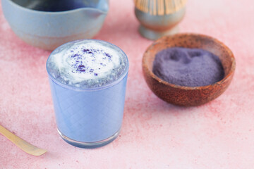 making blue matcha latte on pink background