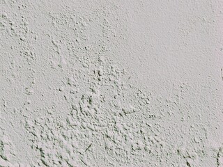 The paint appears bubbled or blistered due to trapped humidity within the concrete wall, white concrete wall texture. Abstract background for design.
