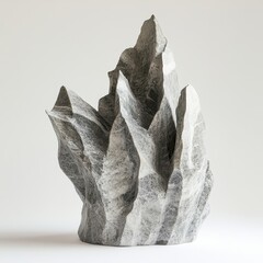 A strikingly rugged sculpture of jagged stone with sharp edges stands out against a pristine white backdrop, exuding artistic allure.