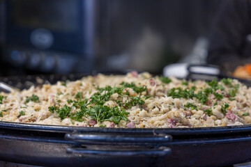 Street food. Grilled meat and side dish on a large pan for sale at the market