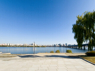 panorama view of the river, Yeouido Hangang River Park, in Seoul, Korea, with a broad bridge, and a cityscape in the backdrop