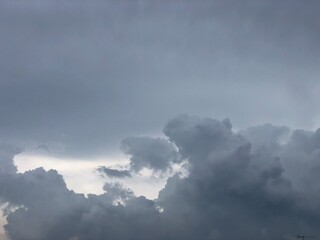 Movement of Beautiful dark rain storm clouds reveals the sun, thunderstorm in dramatic sky, with lens flare. Climate cloudscape scenic. Weather tropical summer squall. © praditkhorn