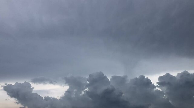 Movement of Beautiful dark rain storm clouds reveals the sun, thunderstorm in dramatic sky, with lens flare. Climate cloudscape scenic. Weather tropical summer squall.