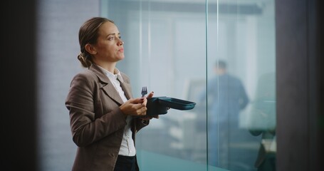 Caucasian successful businesswoman or office worker eats food from delivery taking break during...