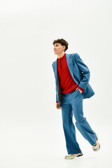 A stylish man in a vivid blue suit strolls confidently, highlighting modern fashion.