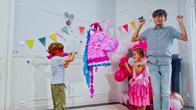 Little blindfolded boy enjoys a playful pinata party adventure