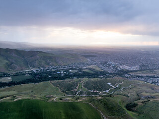 Mountain landscape in summer at sunset. Green and fields on the hills. Village near the mountains....
