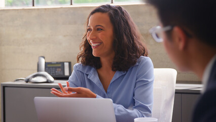 Close Up Of Business Team Meeting Around Table In Modern Office For Presentation 