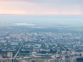 Fototapeta premium Drone view of the town at sunset. Haze covered the buildings and streets. Evening cityscape.
