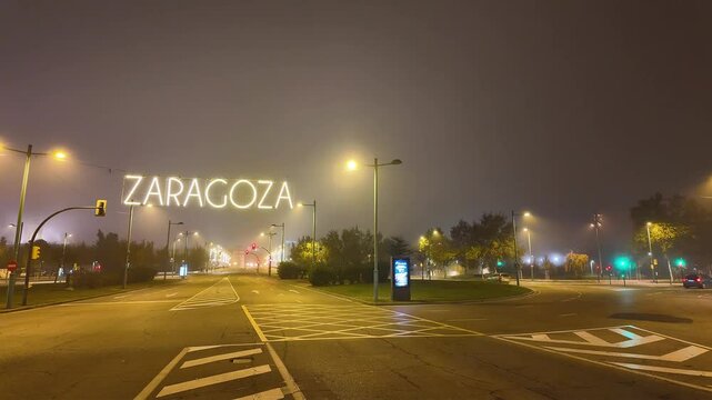traffic of the city of zaragoza at night with fog and illuminated