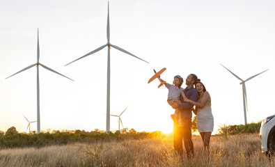 Family with son walking on field on wind farm. Happy Family and son playing at the Wind turbines...