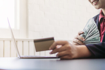 Businesswoman holding credit card in hand to key in credit card information pay for store while ordering products online via application because paying by credit card increases convenience of payment.
