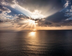 sunlight streaming through clouds over the ocean illuminating the water with soft rays creating a peaceful divine atmosphere