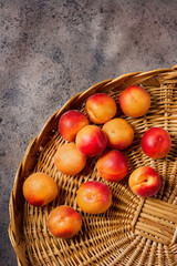 Fresh Apricots in a Rustic Basket with Textured Background.