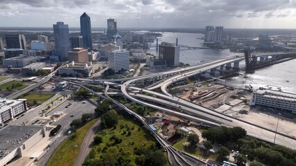 Obraz premium Jacksonville, Florida city skyline beside St. Johns river downtown office buildings and streets working and living in coastal town in morning light as storm front passes over