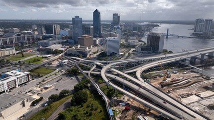 Jacksonville, Florida city skyline beside St. Johns river downtown office buildings and streets...