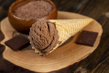 chocolate ice cream in a cone on a board