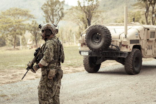 United States Army in camouflage uniforms operation in the forest.with armored vehicle, soldiers training  in a military operation