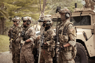 United States Army in camouflage uniforms operation in the forest.with armored vehicle, soldiers training  in a military operation