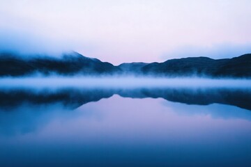 Fototapeta premium Serene Lake Mist Mountains Reflecting Dawn